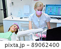 Dentist and patient looking at dental scan on laptop screen. 89062400