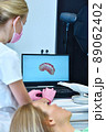 Dentist and patient are watching result of a 3D scan on a laptop screen 89062402