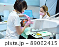 Woman patient with protective glasses and retractor for teeth whitening procedure 89062415