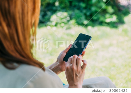 a young girl on a swing works in the phone, looks, moves her finger, Prores422. 89062425