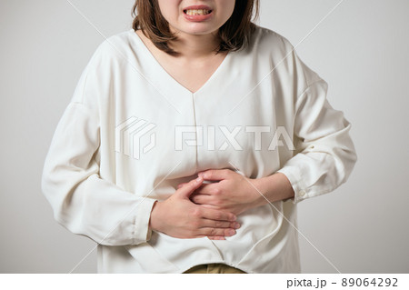 お腹が痛くて手でおさえる若い女性 89064292