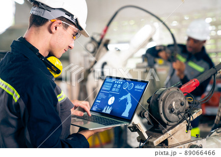 Young factory worker working with adept robotic arm Young factory worker working with adept robotic arm 89066466