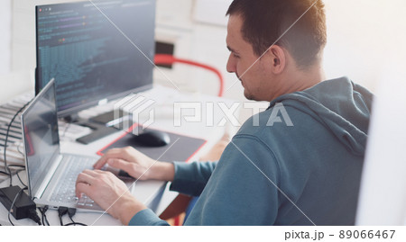 A man in a turquoise sweater in a bright office while working at a computer close-up. Work illustration A man in a turquoise sweater in a bright office while working at a computer close-up. Work illustration 89066467