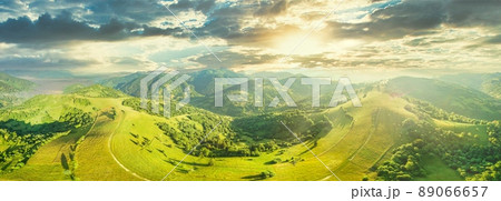 Aerial view of the endless lush pastures of the Carpathian expanses and agricultural land. Cultivated agricultural field. Rural mountain landscape at sunset. Ukraine. 89066657