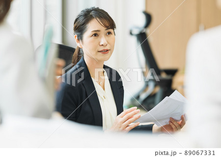 オフィスで部下と話をするミドルのキャリアウーマン 89067331