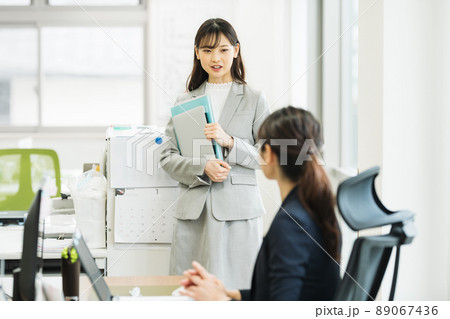 オフィスで会話をする女性 89067436
