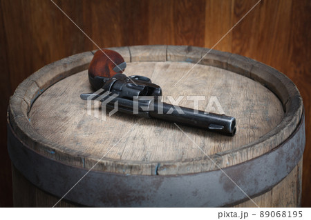 Old west revolver 45 cal on wooden barrel Old west revolver 45 cal on wooden barrel 89068195