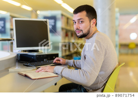 Portrait of man working at a computer in public library Portrait of man working at a computer in public library 89071754