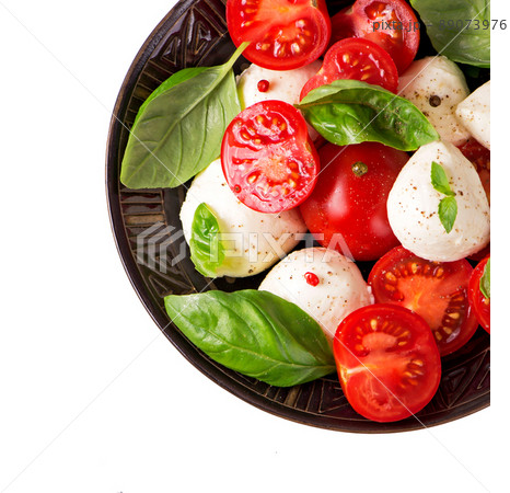 Small tomatoes and cheese. Round camembert cheese with cherry tomatoes and basil on a plate. 89073976