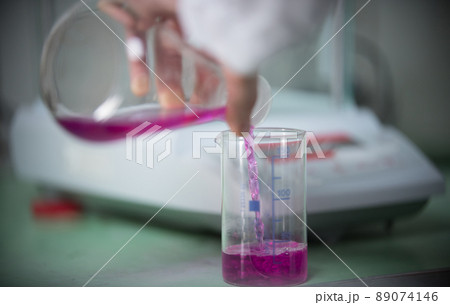 Chemical laboratory. Pouring liquid from one flask to another Chemical laboratory. Pouring liquid from one flask to another 89074146