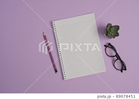 Top view open notebook, glasses, pen and succulent plant on purple background. Top view open notebook, glasses, pen and succulent plant on purple background. 89078451