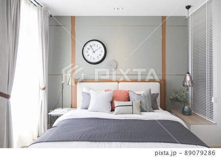 Stylish interior of modern bedroom. White and pastel orange design pillow in cozy bedroom. Stylish interior of modern bedroom. White and pastel orange design pillow in cozy bedroom. 89079286