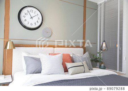 Stylish interior of modern bedroom. White and pastel orange design pillow in cozy bedroom. Stylish interior of modern bedroom. White and pastel orange design pillow in cozy bedroom. 89079288