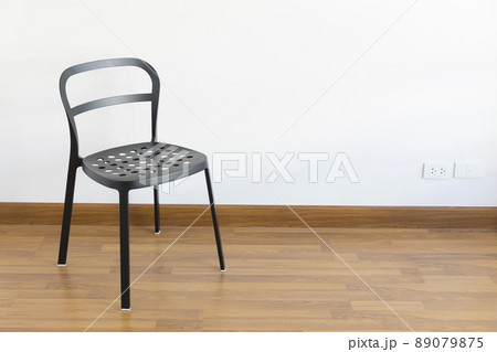 Modern black steel chair on wood floor in empty room. Modern black steel chair on wood floor in empty room. 89079875
