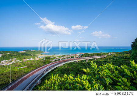 南の島沖縄県の海へと続く大きな橋梁と広い青空と青い海 89082179