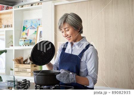 鍋の蓋を開ける女性 鍋の蓋を開ける女性 89082935
