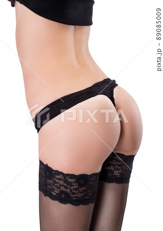 A girl with a perfect figure stands sideways in a beautiful black underwear. Shooting in the studio. Advertising of underwear 89085009