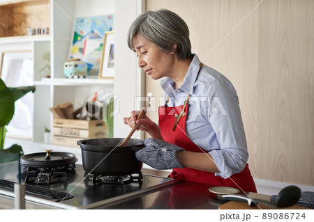 キッチンで調理する女性 89086724
