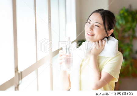 窓際で水分補給する女性 89088355