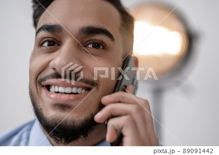 A smiling young businessman with a phone 89091442