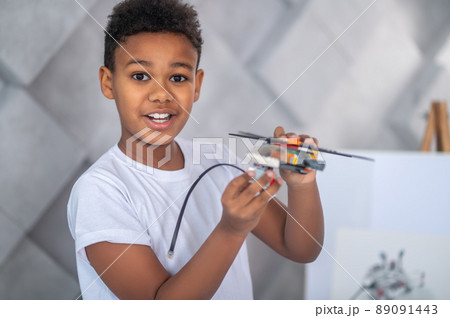 A cute teen looking busy while assembling toy heicopter parts 89091443