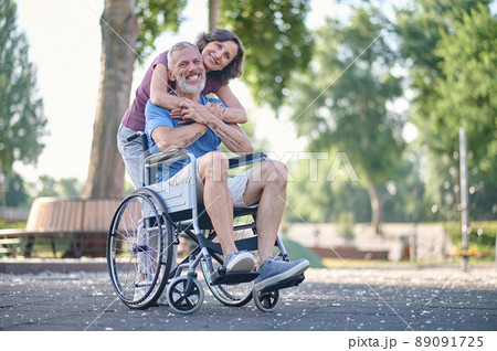 A woman and a man in a wheel chair feeling happy and smiling 89091725