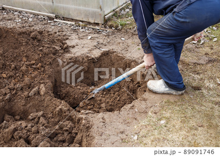 man digging a hole for planting a fruit tree in the garden man digging a hole for planting a fruit tree in the garden 89091746