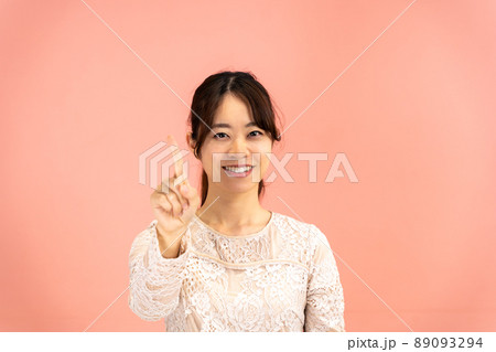 人差し指を立てて決めポーズの若い女性 89093294