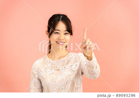 人差し指を立てて決めポーズの若い女性 89093296