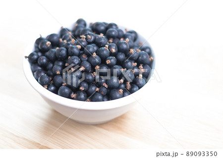 white bowl filled with black currant berries 89093350