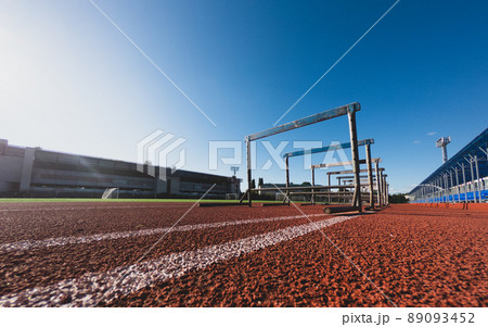 Hurdle race barrier on stadium track at sunny day. Blue sky Hurdle race barrier on stadium track at sunny day. Blue sky 89093452