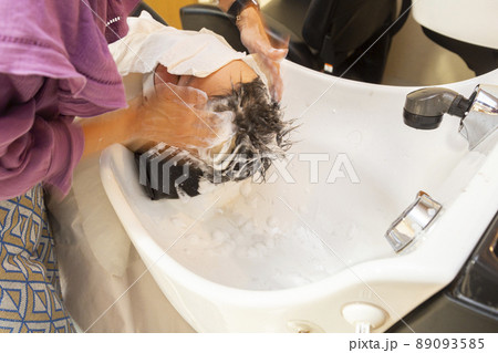 美容室でシャンプーをされる小学生の少年 美容室でシャンプーをされる小学生の少年 89093585