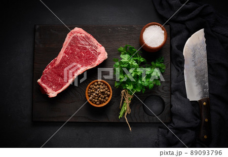 Fresh raw piece of beef meat, striploin steak on a black background, top view. Marbled piece of meat New York 89093796