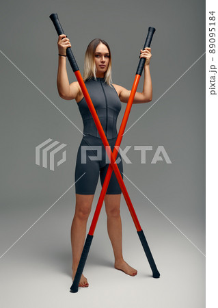 beautiful girl in sports uniform is training kung fu in the studio, fighter athlete, practicing martial arts with a stick beautiful girl in sports uniform is training kung fu in the studio, fighter athlete, practicing martial arts with a stick 89095184