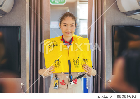 Prior to the flight's takeoff, an air hostess presents safety procedures to passengers. 89096693