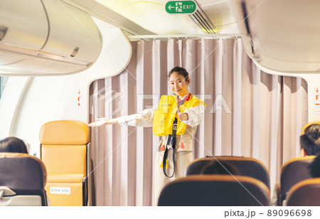 Prior to the flight's takeoff, an air hostess presents safety procedures to passengers. 89096698