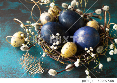 Classic blue 2020. Blue easter eggs in a nest close-up on a blue stone or slate background. 89097560