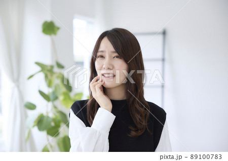 歯が痛くて頬を押さえる女性 89100783