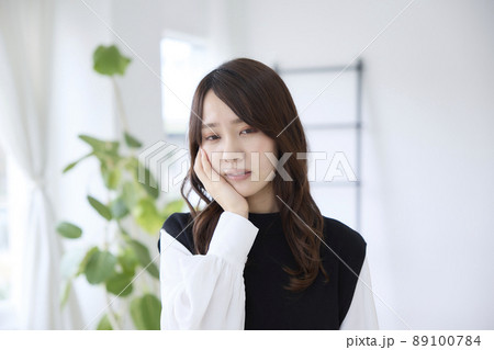 歯が痛くて頬を押さえる女性 89100784
