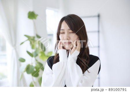 歯が痛くて頬を押さえる女性 89100791