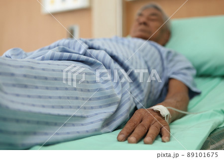 Elderly 80 plus year old man recovering from surgery in a hospital bed.old man sick at hospital 89101675