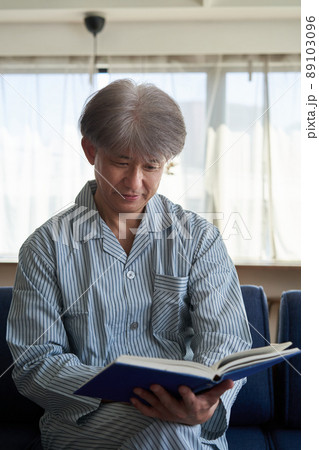 パジャマ姿で読書する男性 パジャマ姿で読書する男性 89103096