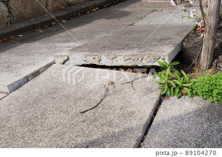 浮き上がった歩道の端の石畳 89104270