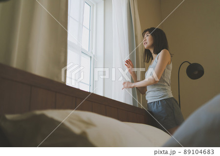 朝、窓の外を眺める女性 89104683