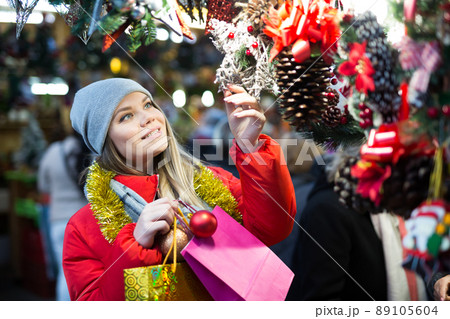 Girl choosing Christmas gifts outdoor on street market Girl choosing Christmas gifts outdoor on street market 89105604