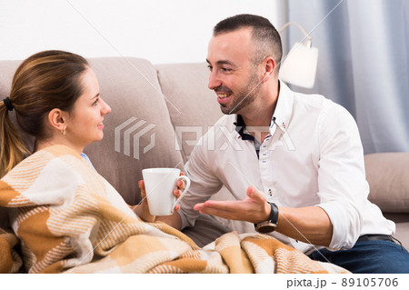 Careful husband is offering warm tea for his wife 89105706