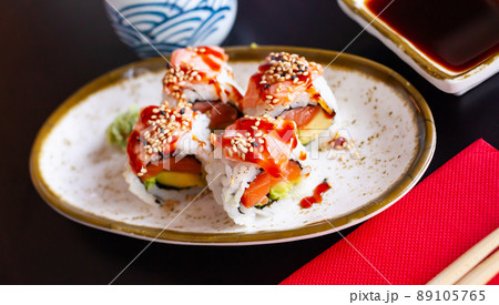 Delicious uramaki sushi from raw salmon fish Delicious uramaki sushi from raw salmon fish 89105765