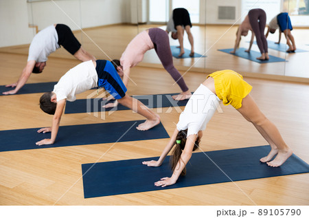 Family of four practicing yoga at gym Family of four practicing yoga at gym 89105790