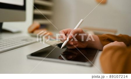Female or graphic designer using stylus pen, drawing on tablet screen. 89107214
