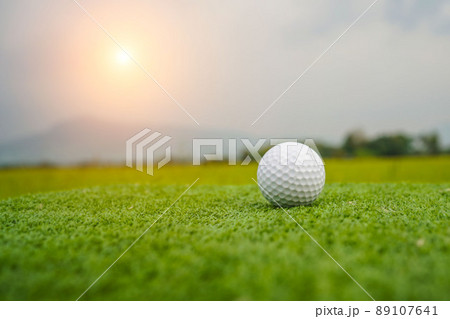 Golf ball on the green with warm tone and sunset. Golf ball on Green field golf course in morning time with soft sunlight. Golf ball on the green with warm tone and sunset. Golf ball on Green field golf course in morning time with soft sunlight. 89107641